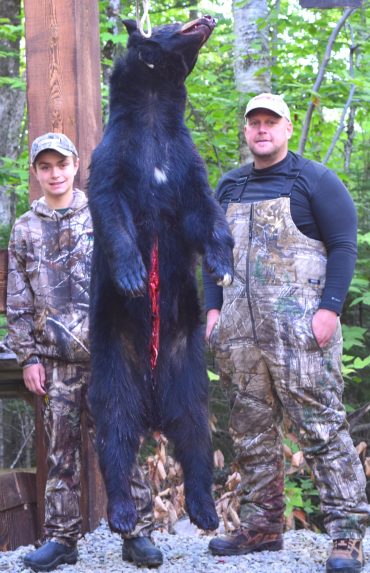 Father and son bear hunting partners with trophy bear at Foggy Mountain Guide Service